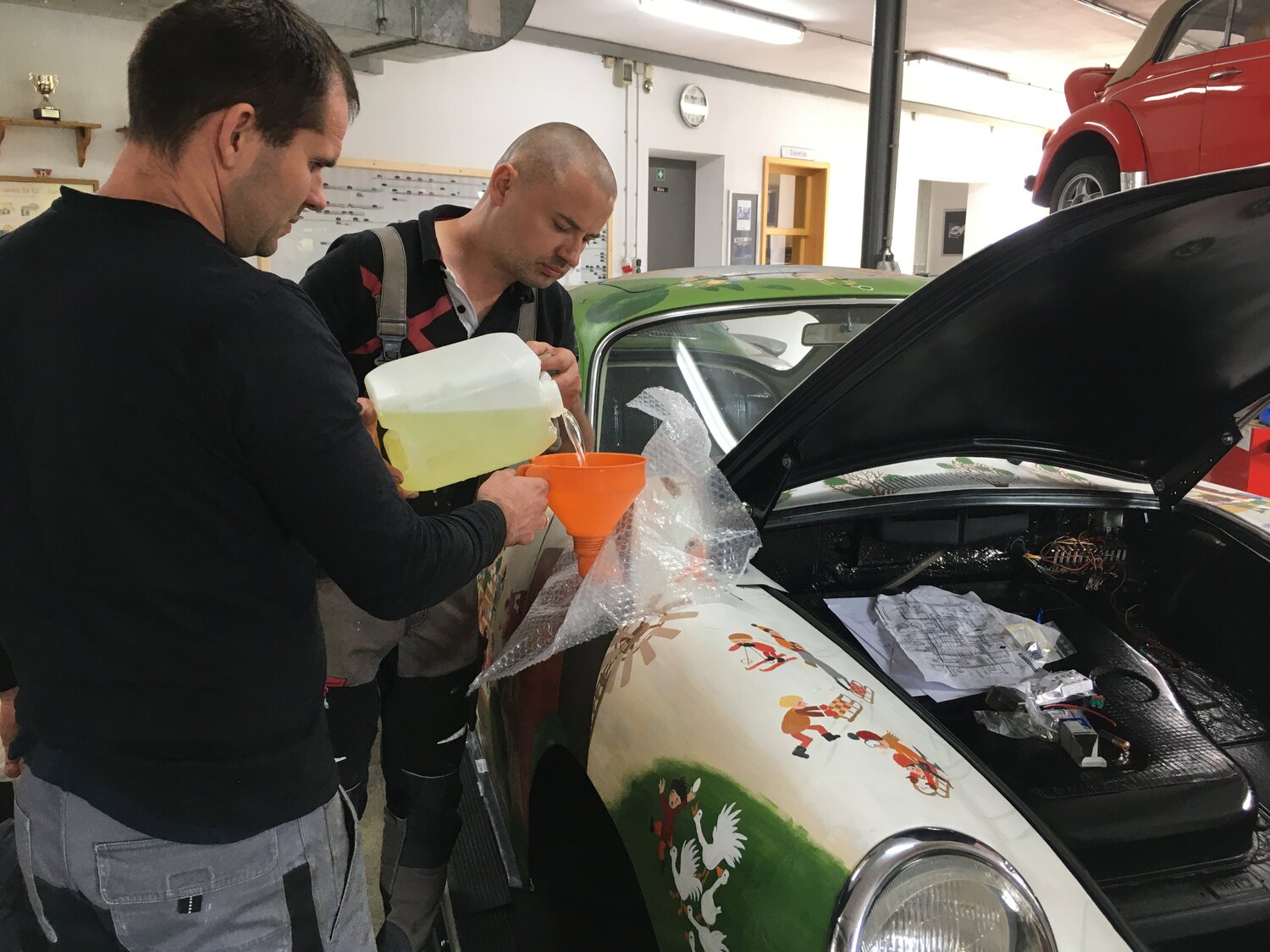 Kinder mit dem fertigen Wimmelporsche in der Werkstatt