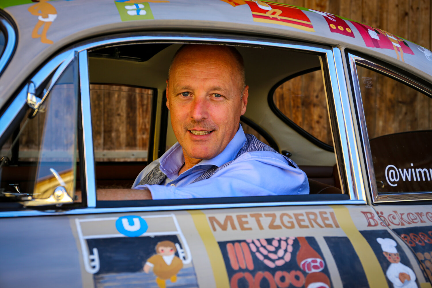 Helmut Freinecker mit dem Wimmelporsche vor der Werkstatt